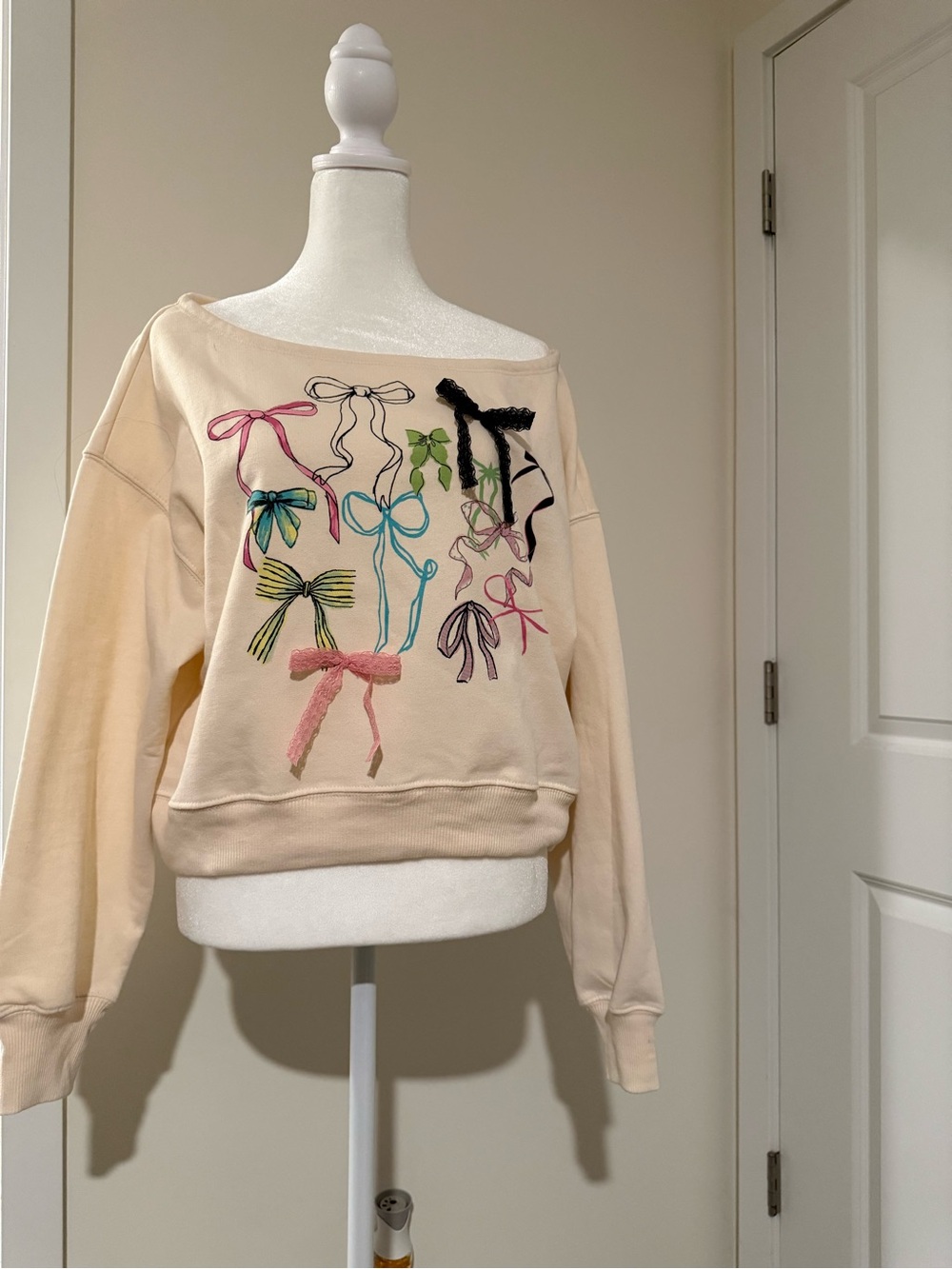 Modern Lux Cream Off-Shoulder Sweatshirt with Multicolor Bow Motif
